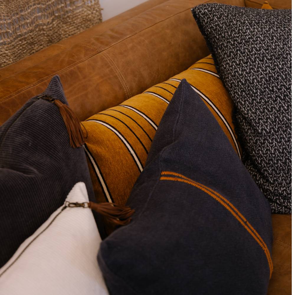Close-up of decorative pillows on a brown leather sofa