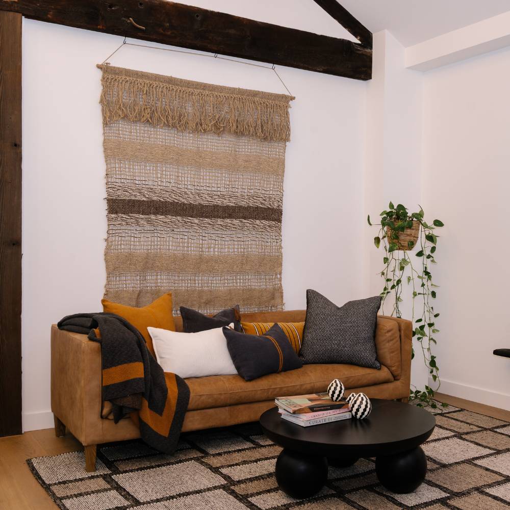Living room with a brown sofa, decorative pillows, and a coffee table.