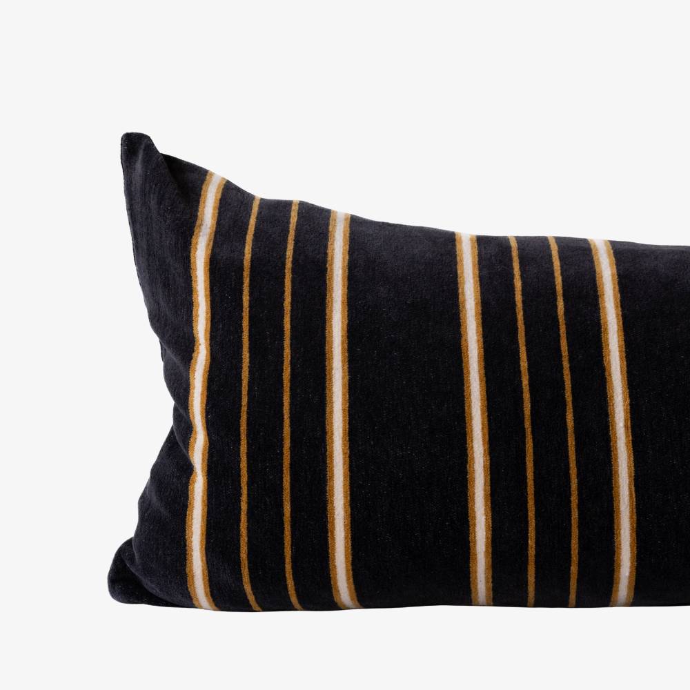 Black pillow with brown and white stripes on a white background
