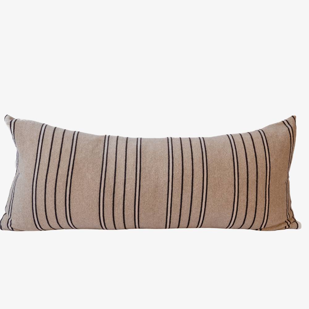 Striped beige pillow with black and white pattern on a white background