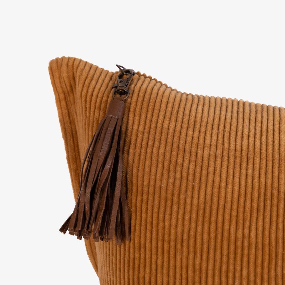 Brown ribbed pillow with a leather tassel on a white background