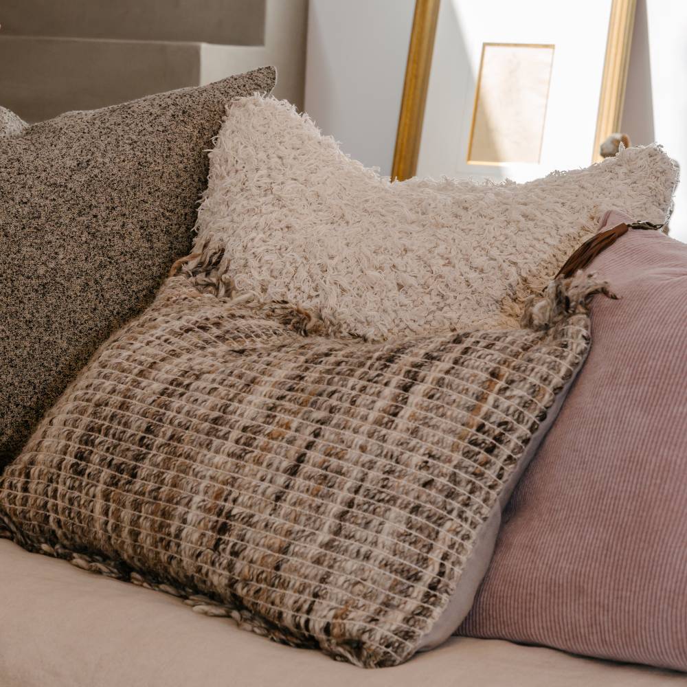 Close-up of textured pillows on a sofa with a neutral color scheme.