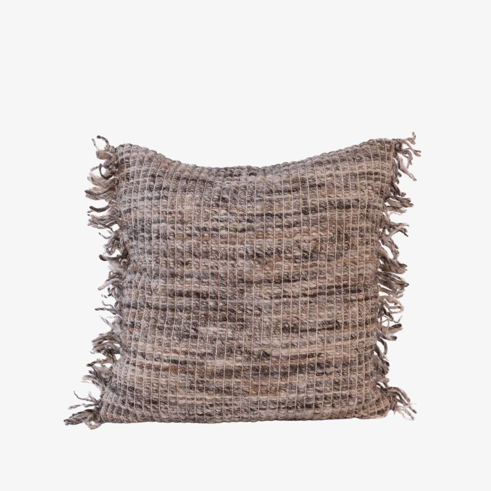 Textured pillow with fringes on a white background