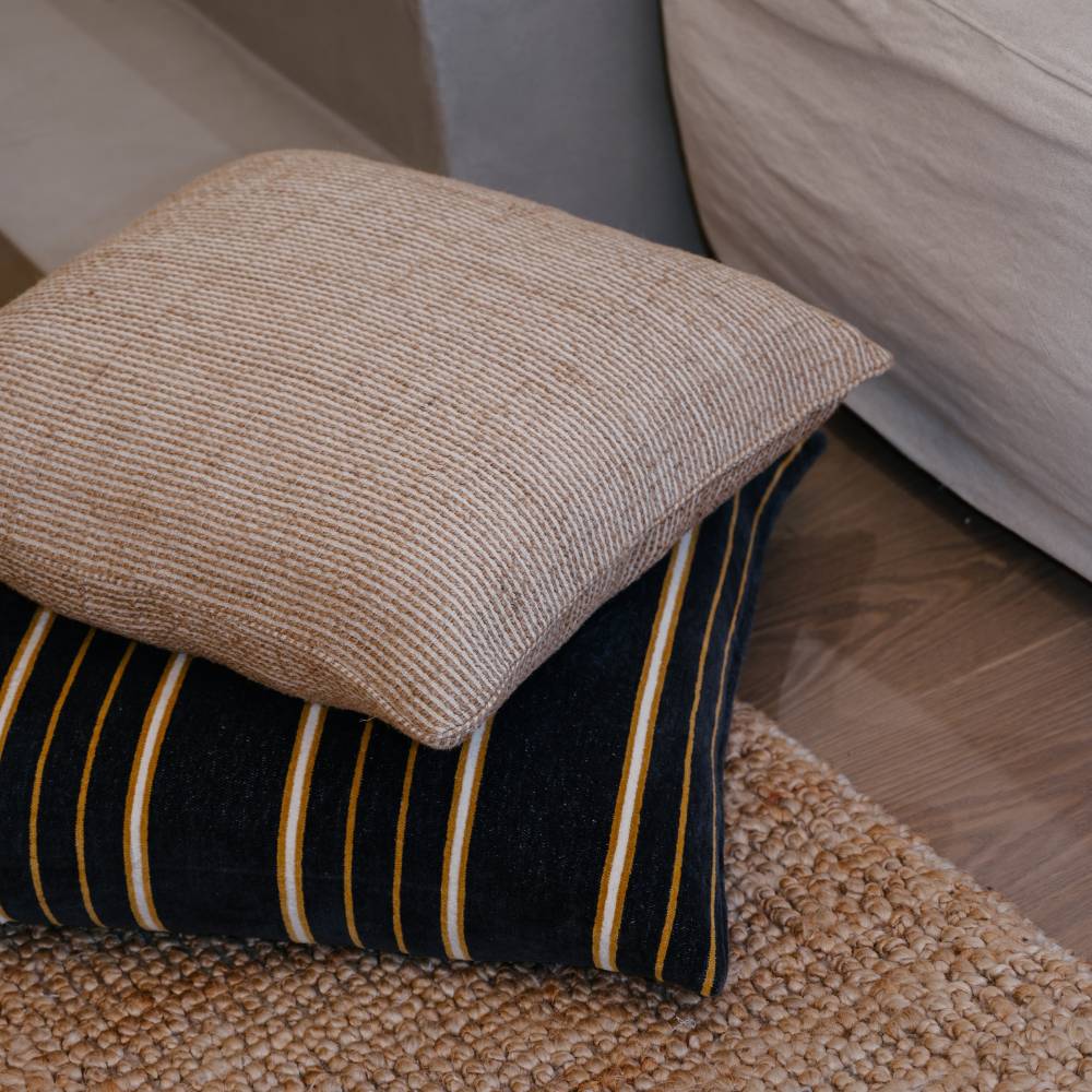 Close-up of a textured pillow on a striped cushion with a blurred background