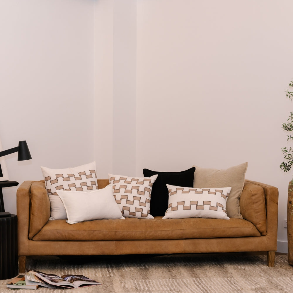 Brown sofa with geometric patterned cushions in a living room setting