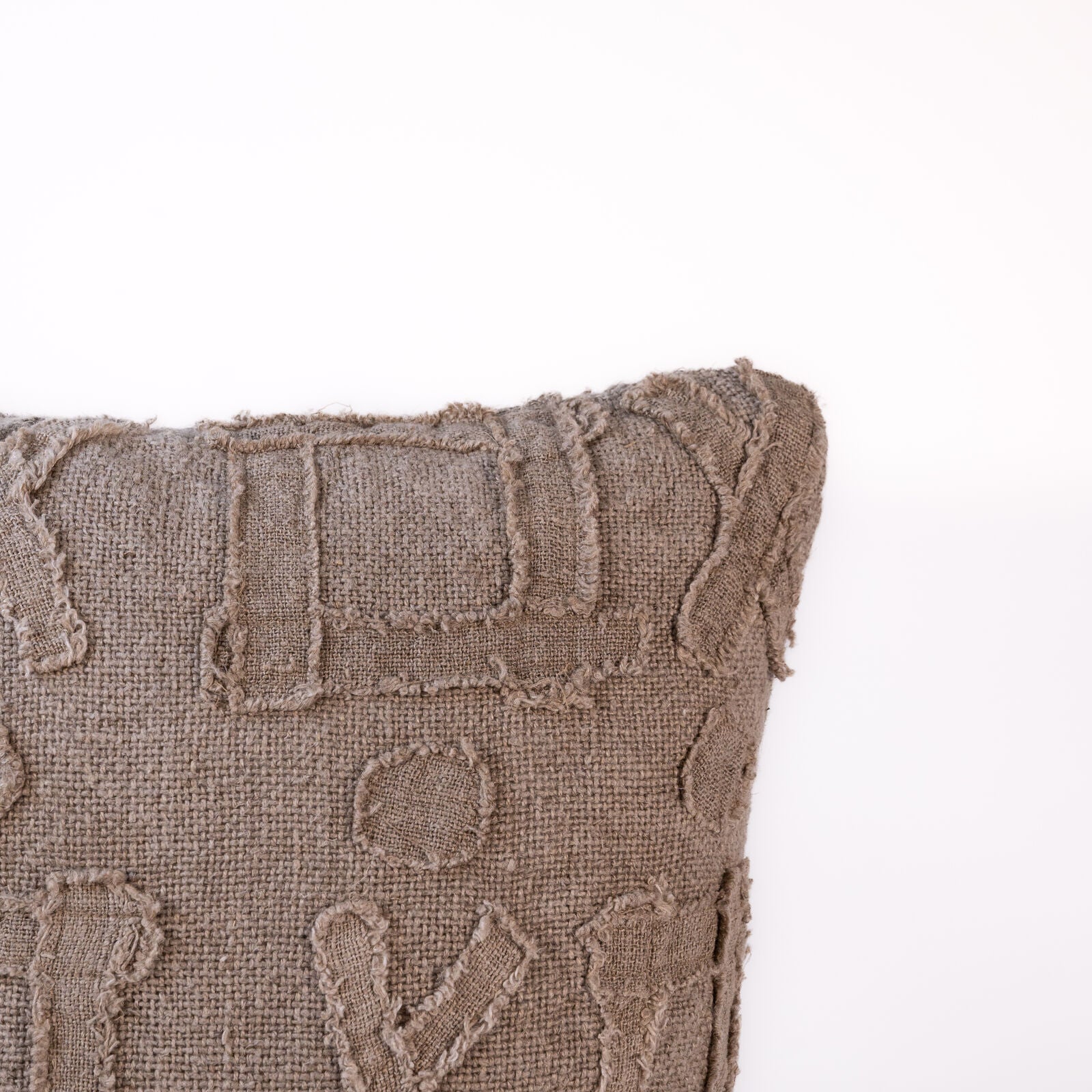 Textured brown pillow with geometric patterns on a white background