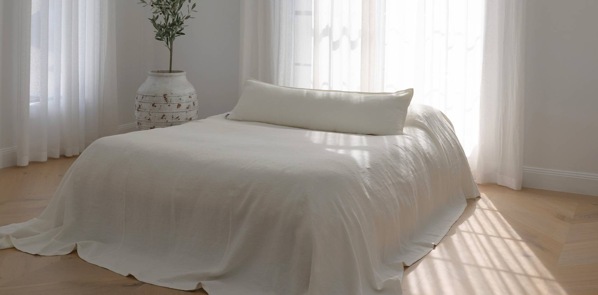 Luca Off-white bed cover, styled for summer with a Luca off-white long lumbar