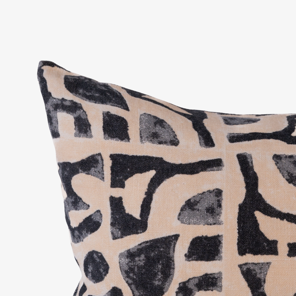 Decorative pillow with black abstract pattern on beige background