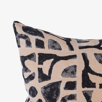 Decorative pillow with black abstract pattern on beige background