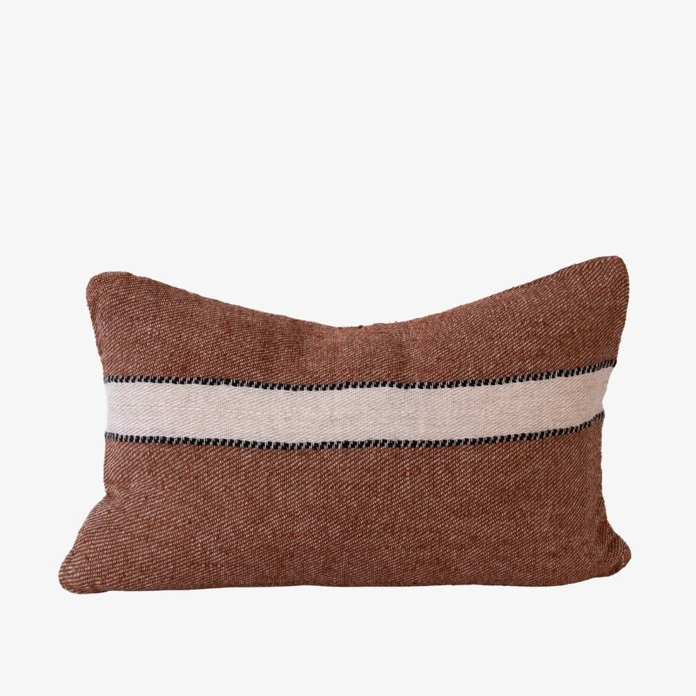 Brown pillow with a white and black striped pattern on a white background