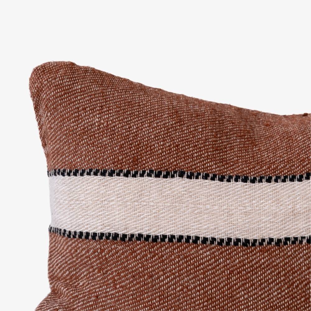 Textured pillow with brown, white, and black stripes on a white background