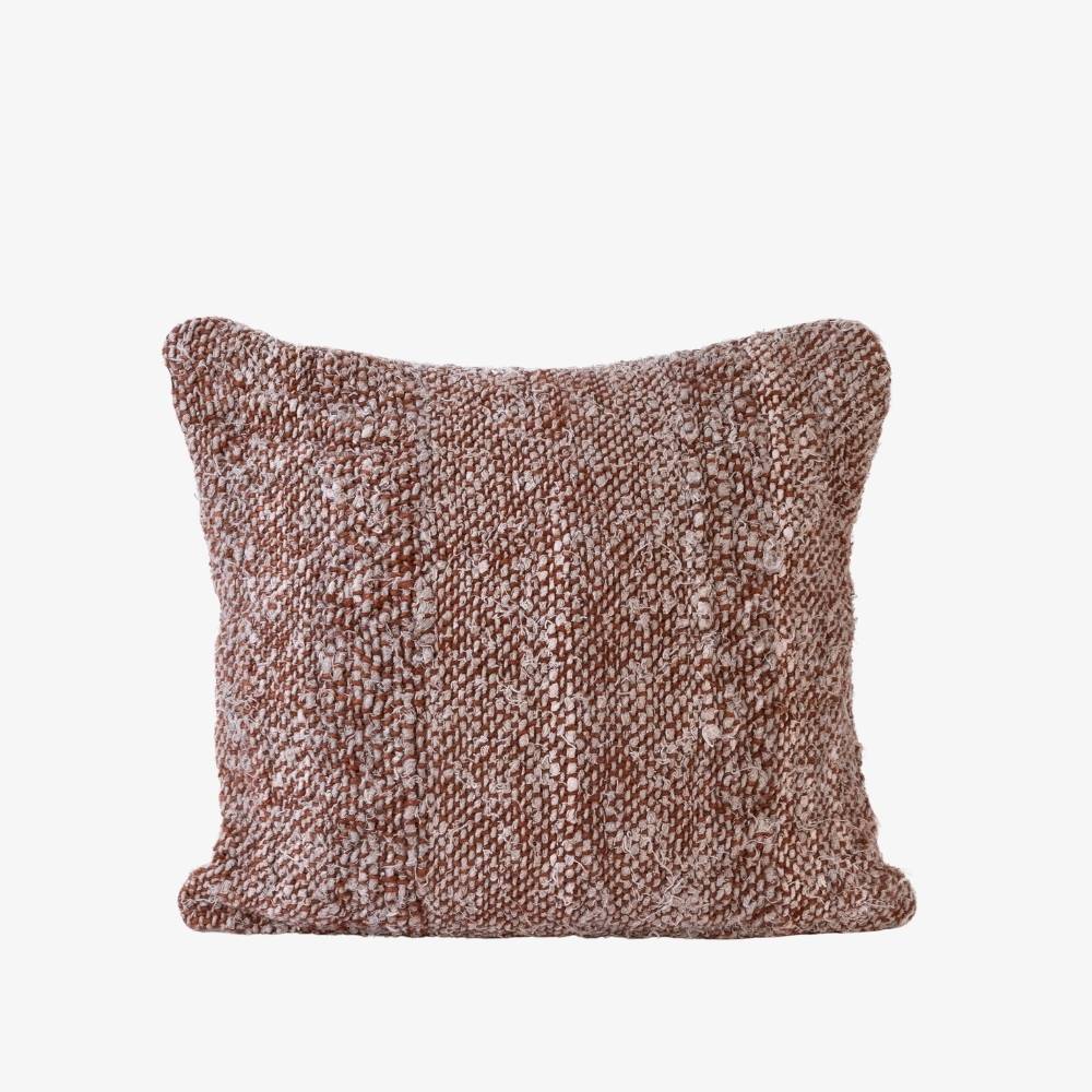 Textured brown pillow on a light beige background