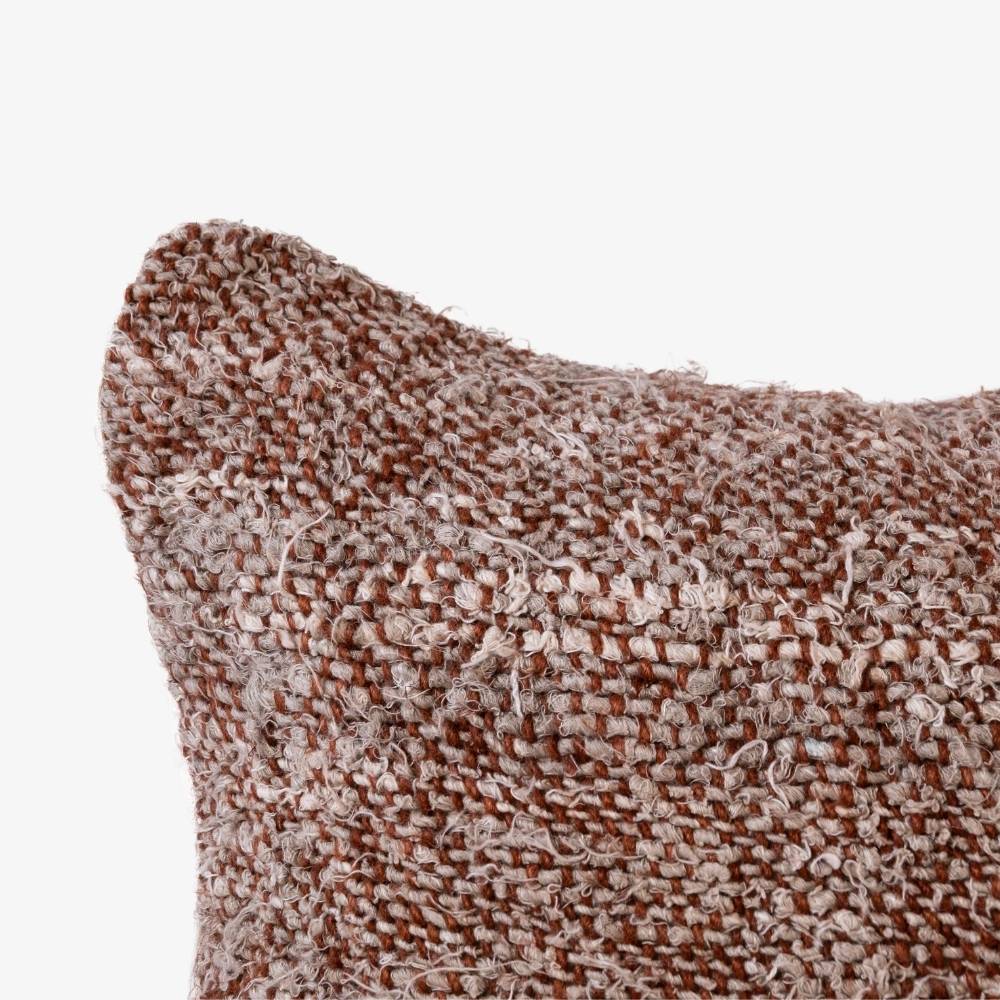Textured brown and beige pillow on a white background