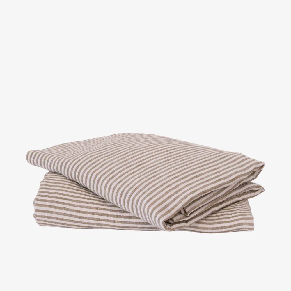 Folded striped bed sheet and pillowcase set on a white background