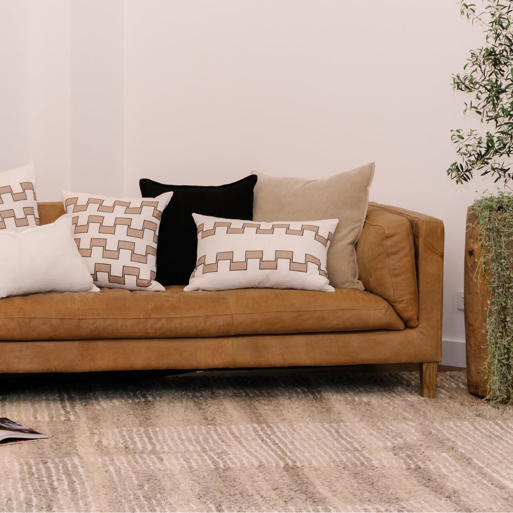 Brown sofa with patterned cushions in a living room setting