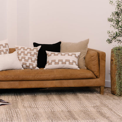 Brown sofa with patterned cushions in a living room setting