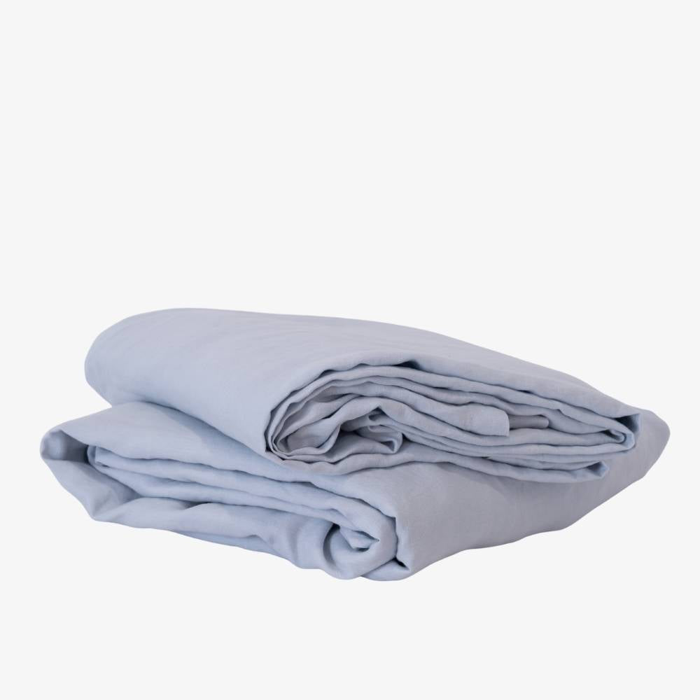 Folded light blue blanket on a white background