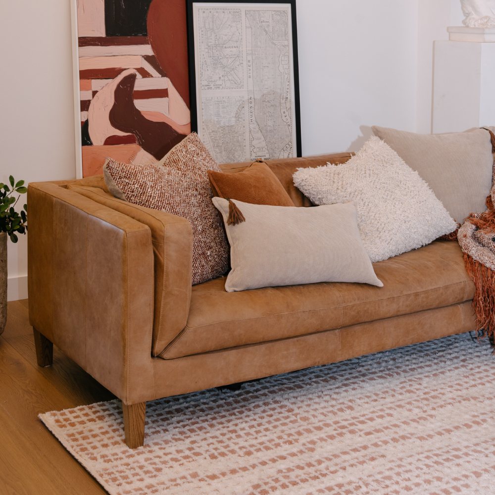 Brown sofa with decorative pillows in a living room setting
