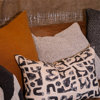 Decorative pillows on a textured sofa with a focus on patterned pillow.
