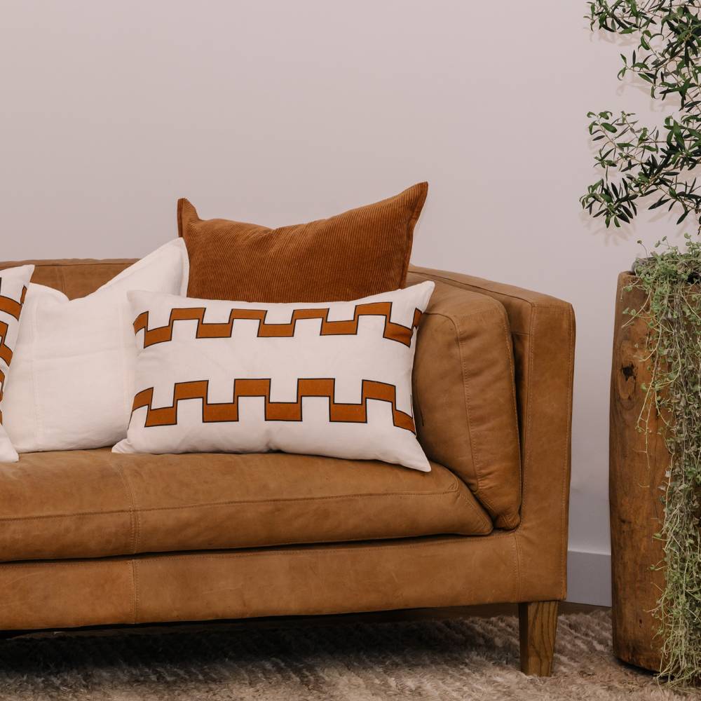 Brown sofa with patterned cushions in a living room setting