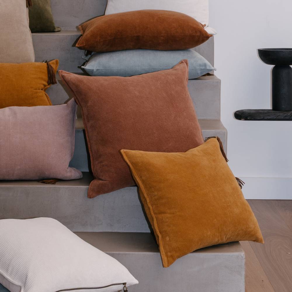 Colorful pillows on a staircase with a modern interior setting.