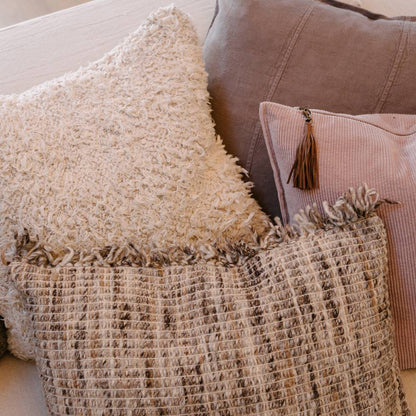 Close-up of textured pillows and a blanket on a sofa