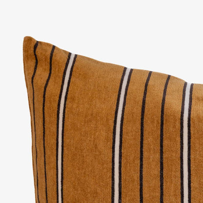 Striped pillow with brown, black, and white stripes on a white background