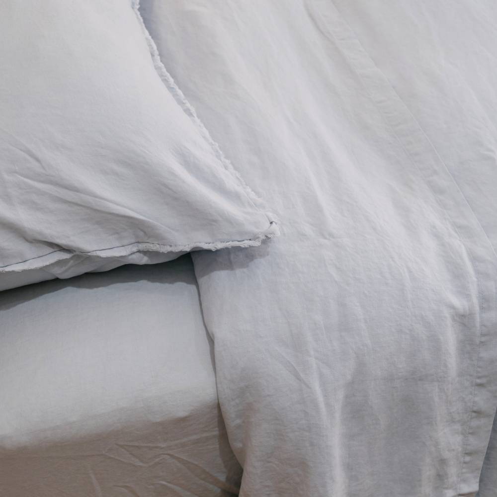 Light blue bedding set with a pillow and duvet on a bed.