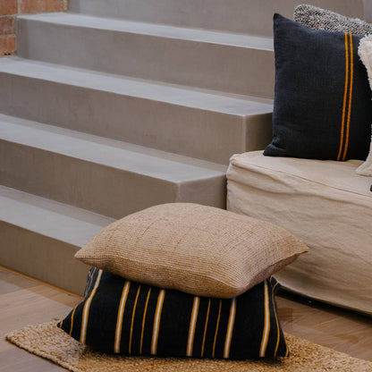 Decorative pillows on a step with a neutral background