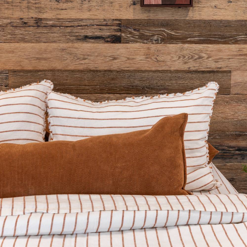 Striped pillows and a brown pillow on a wooden headboard