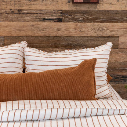 Striped pillows and a brown pillow on a wooden headboard