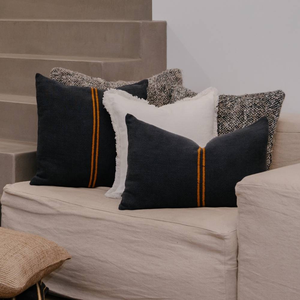 Decorative pillows on a beige sofa with a neutral background