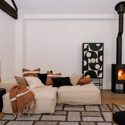 Modern living room with a white sofa, decorative pillows, and a fireplace.
