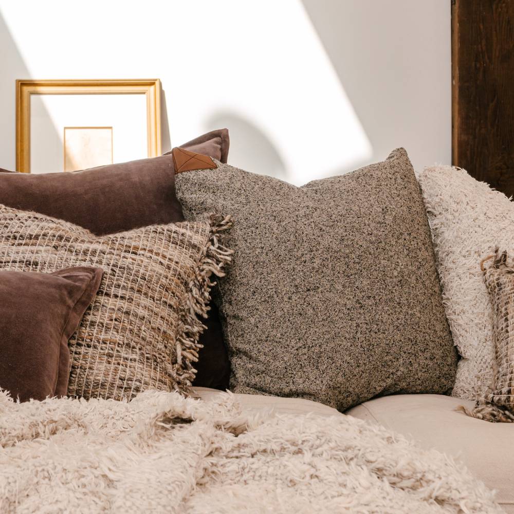 Close-up of textured pillows on a sofa with a neutral background