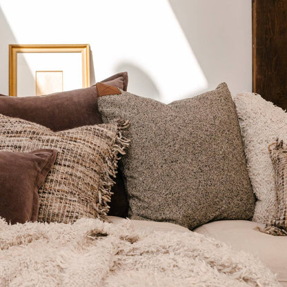 Close-up of textured pillows on a sofa with a neutral background