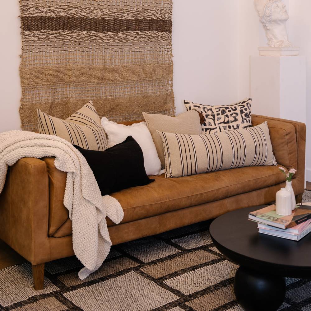 Brown sofa with patterned cushions in a living room setting