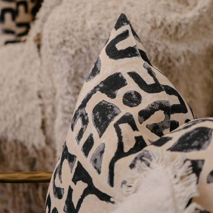 Decorative pillow with black geometric pattern on beige background