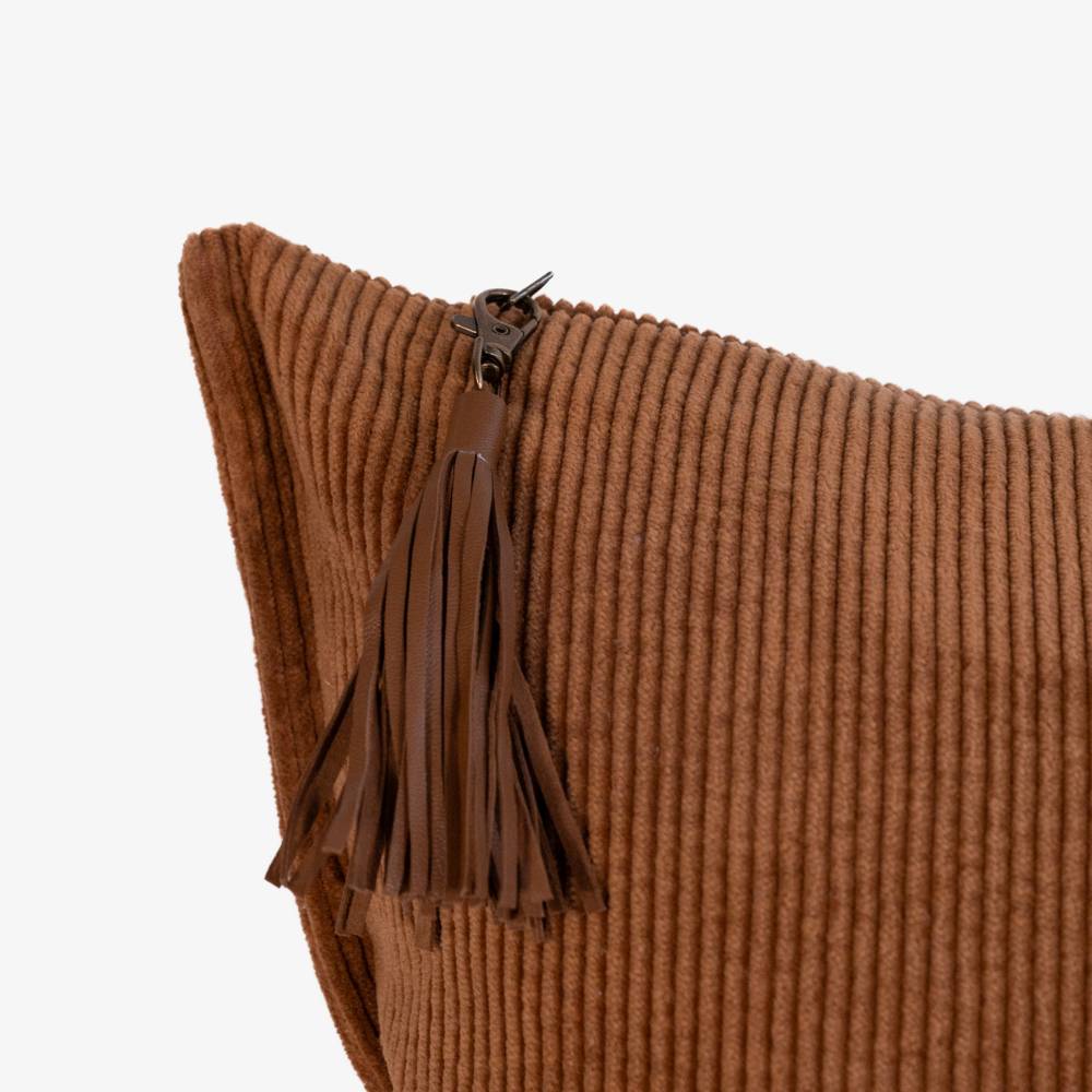 Brown textured pillow with tassel on a white background