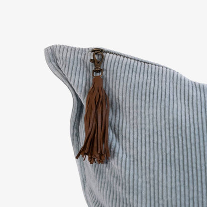 Light blue cushion with a brown leather tassel on a white background