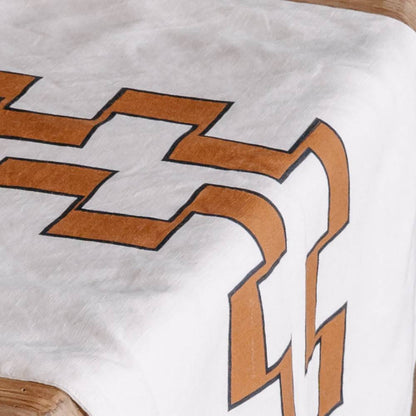 Close-up of a white runner with a nutmeg geometric pattern on a wooden surface