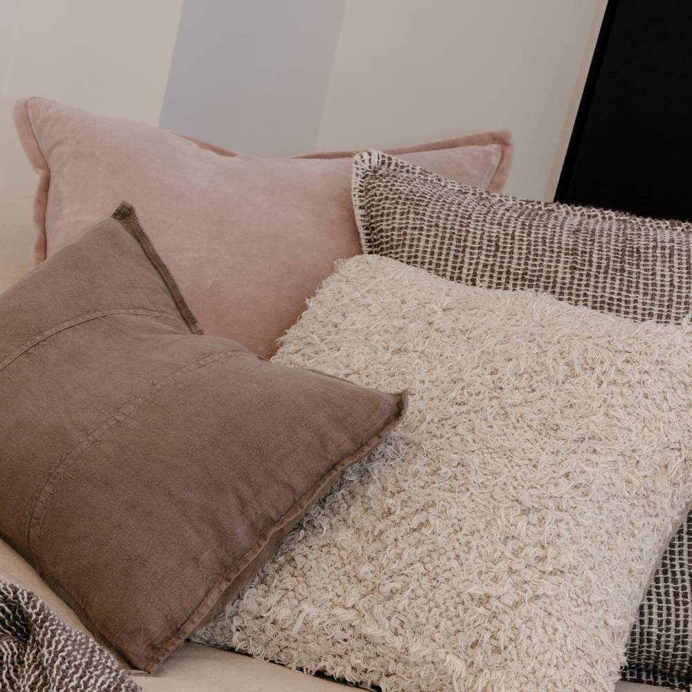 Close-up of textured pillows on a sofa with a neutral background