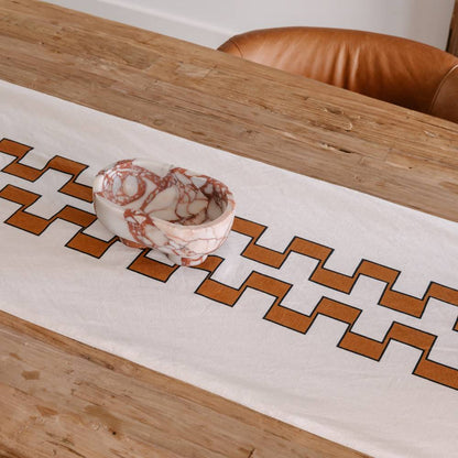 Table runner with geometric pattern on a wooden table