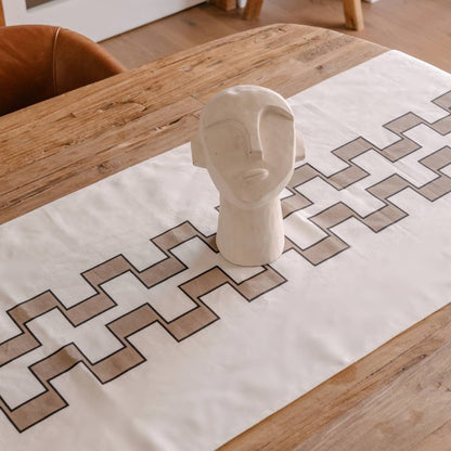 Decorative table runner with geometric pattern on a wooden table