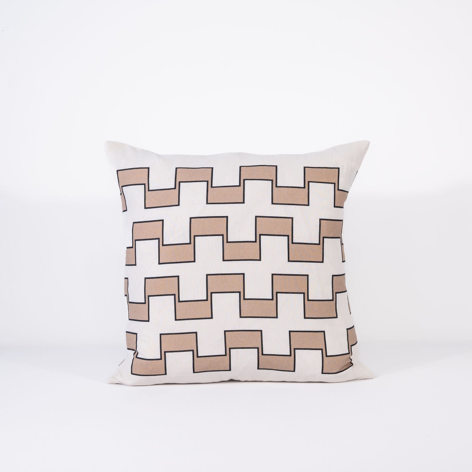 A pillow with a repeating geometric pattern of interlocking beige and white outlined in black on a white background