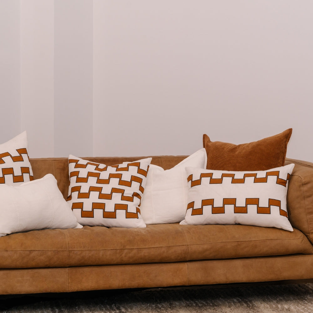 Brown sofa with geometric patterned cushions in a living room setting