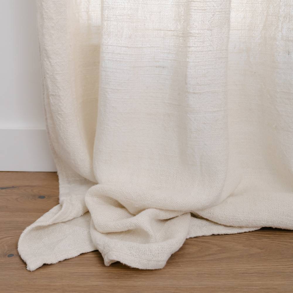 White textured blanket draped over a wooden surface