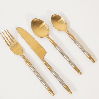 Set of gold cutlery including a knife, fork, and two spoons on a white background