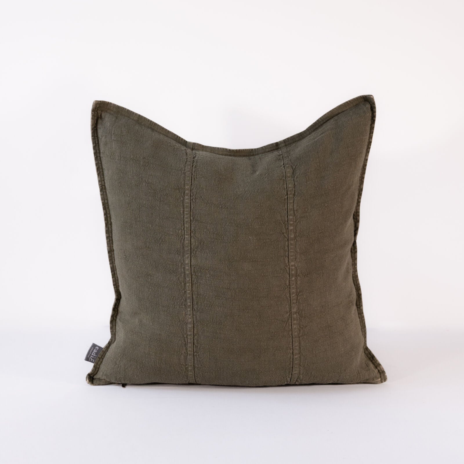 A close-up of a square, textured pillow in a deep, muted olive green color, with subtle vertical stitching details.