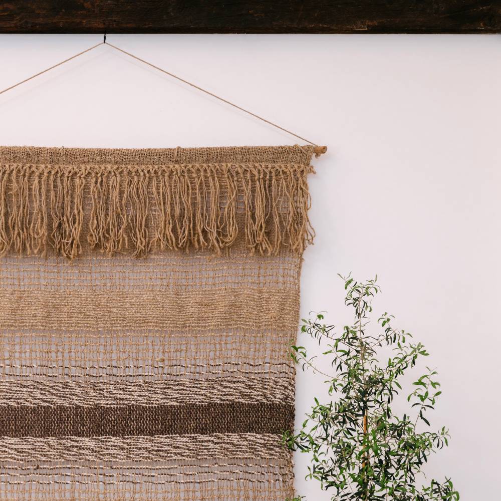 Textured beige blanket with fringes on a wooden surface
