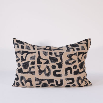 Decorative rectangular pillow with black abstract pattern on beige background